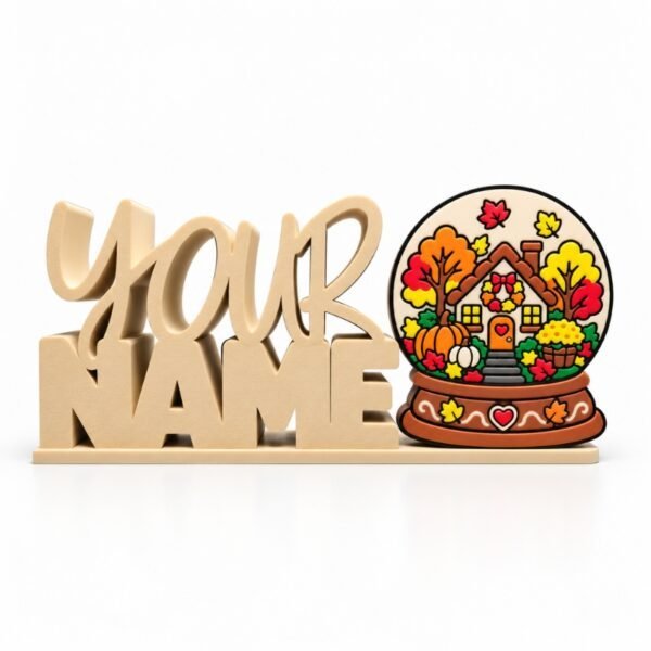 Cream-colored personalized Namelet desk sign featuring the interchangeable Autumn Snow Globe SideKick with a charming autumn cottage, pumpkins, and colorful fall foliage.