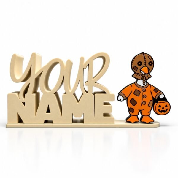 Personalized cream-colored YOUR NAME Namelet desk sign featuring the interchangeable Goosebumps SideKick, a Halloween goose wearing an orange patchwork costume and stitched mask while holding a jack-o'-lantern trick-or-treat bucket.