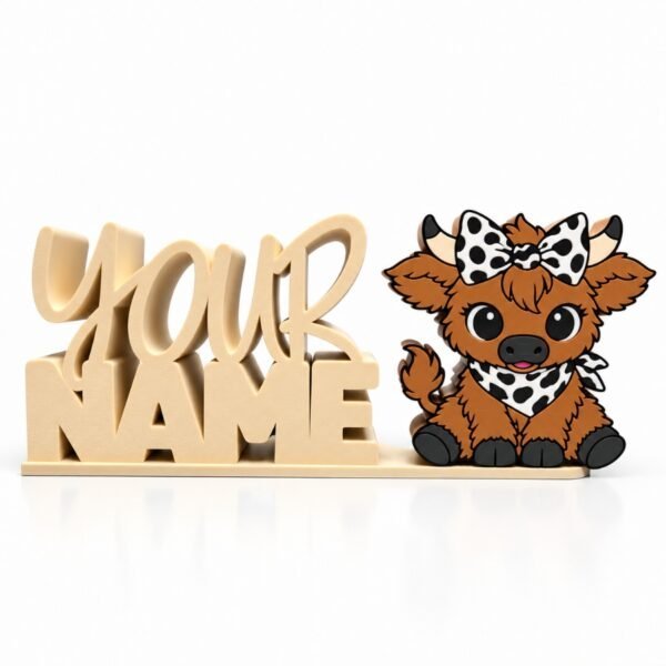 Moo-tiful Highland Cow SideKick featuring an adorable brown Highland cow with a black-and-white cow print bow and bandana, displayed beside a personalized cream Namelet desk sign by Embellish Queen.